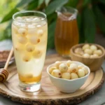 Lotus Seed Honey Drink served in a glass with lotus seeds, honey, and additional ingredients on a wooden tray.
